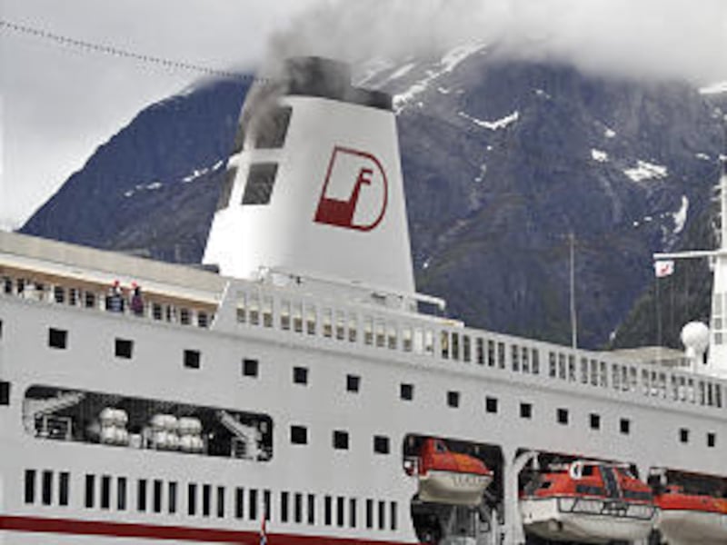 The ship MS Deutschland billows smoke from a machine room fire in Eidfjord, Norway Sunday May 23, 2010. A machine room fire on a German cruise ship at a port in western Norway forced the evacuation of 607 people Sunday, rescue officials said.