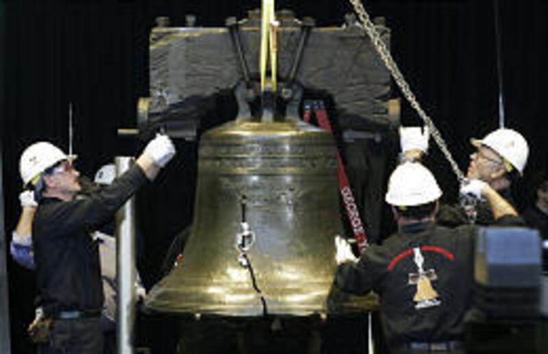 Crews lower the Liberty Bell onto a new pedestal inside the Liberty Bell Center across from Independence Hall in Philadelphia Thursday. A team of engineers walked alongside the 2,080-pound bell during the move, monitoring with a hand-held electronic devic