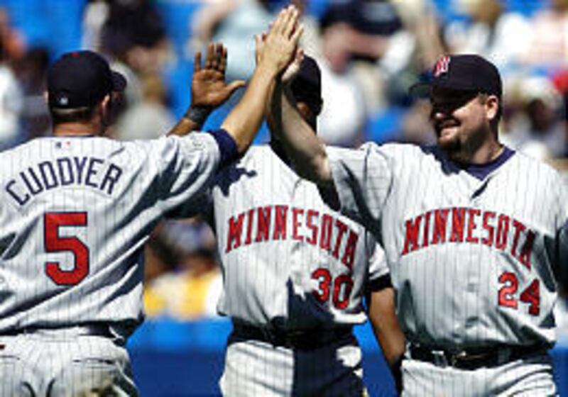 Twins' Matthew LeCroy, right, is congratulated following his pinch-hit ninth-inning grand slam vs. Toronto. The Twins defeated the Blue Jays, 6-5.