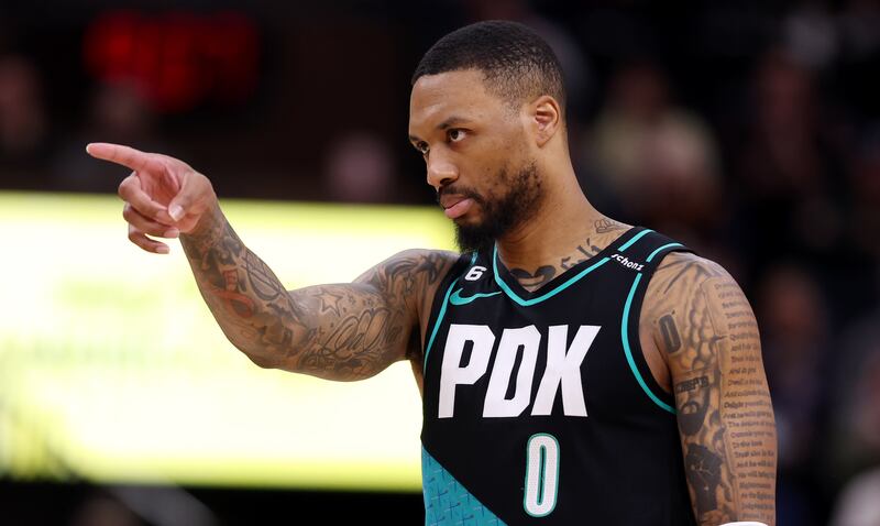 Portland Trail Blazers guard Damian Lillard (0) points at a teammate in a 2023 game against the Utah Jazz at Vivint Arena.