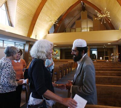 Dee Rowland talks with Imam Muhammed Mehtar following "Hope with Immigrants," an interfaith service of reflection and prayer at Zion Evangelical Lutheran Church in Salt Lake City, Saturday, May 11, 2013.