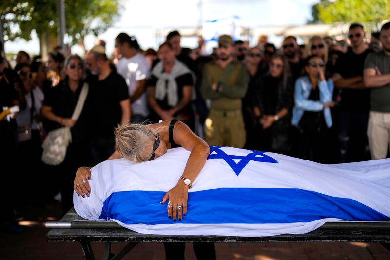 Antonio Macías’ mother cries over her son’s body covered with the Israeli flag at a cemetery near Tel Aviv, Israel, on Oct. 15, 2023.