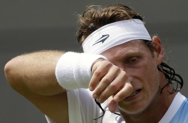 David Nalbandian of Argentina wipes his face during a first round men's singles match against Janko Tipsarevic of Serbia at the All England Lawn Tennis Championships at Wimbledon, England, Monday, June 25, 2012.