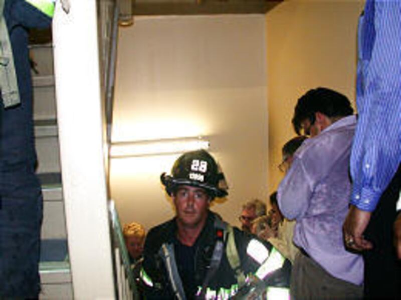 Engine 28 firefighter Mike Kehoe of Staten Island helps evacuate people from the stairwell of Tower One during the attacks on New York's World Trade Center on Sept. 11, 2001. Kehoe escaped before the towers collapsed; 343 firefighters did not survive.