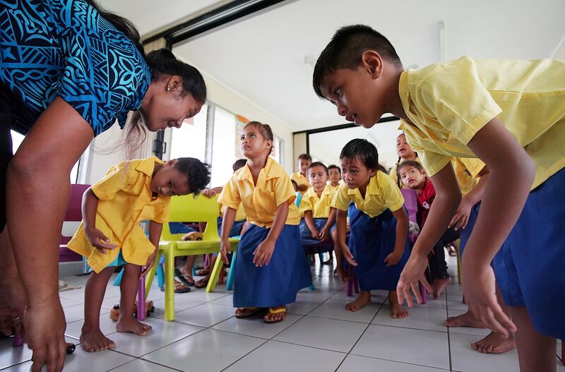 Teacher Sia Osa participates in an activity with Benedict Phillip, right, and other students at Foundational Learning preschool at the Siumu Ward in Siumu, Samoa on Thursday, May 16, 2019.