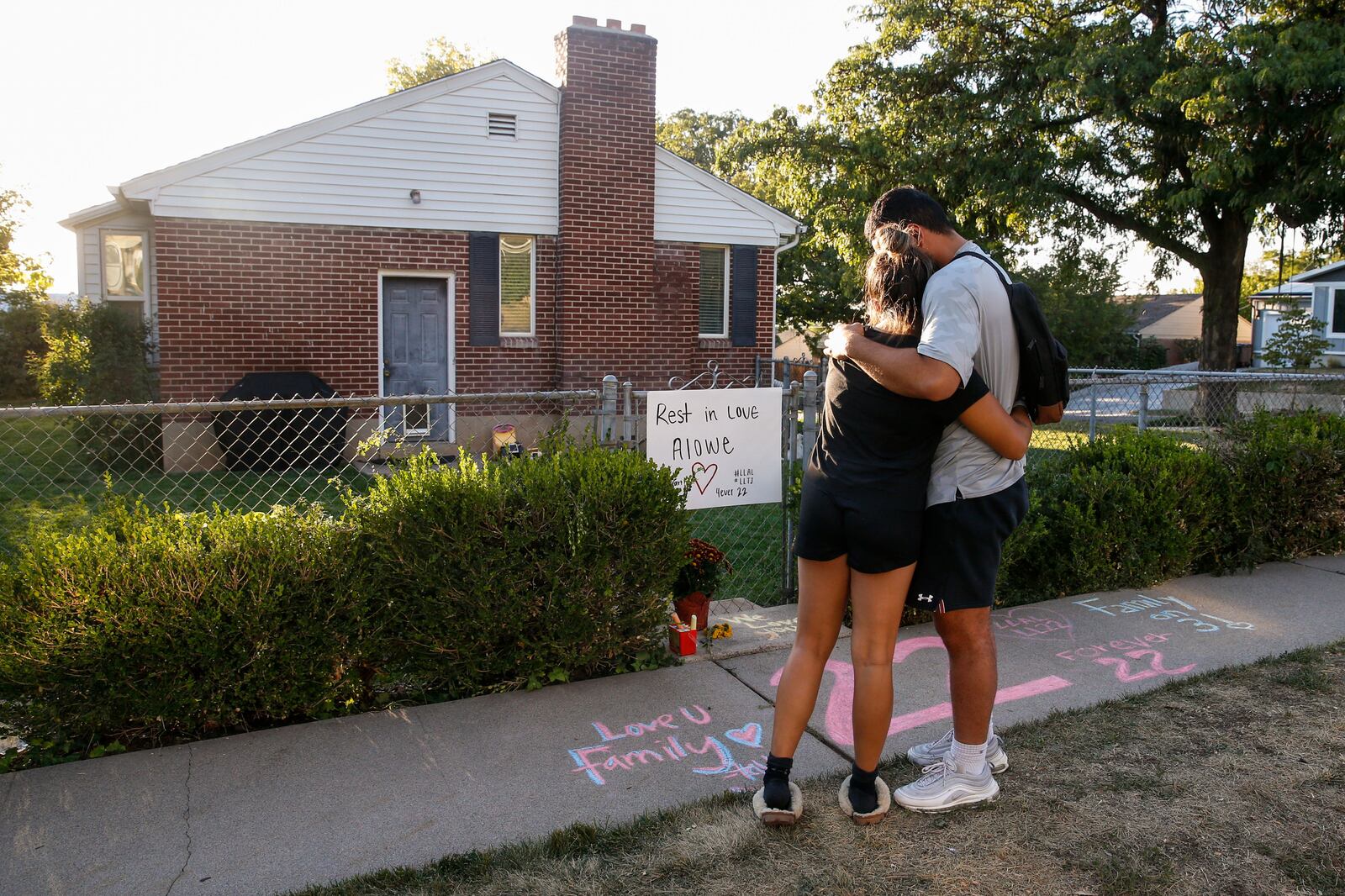 Samuelu Elisaia and Madison Jacobus embrace each other in front of a makeshift memorial for Aaron Lowe.