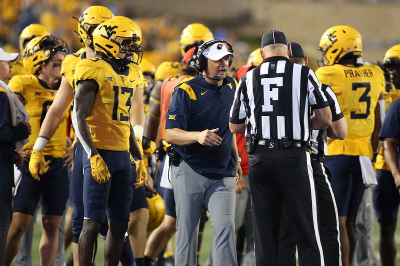 West Virginia coach Neal Brown, center, speaks with an official during game against Kansas in Morgantown, W.Va., Saturday, Sept. 10, 2022.