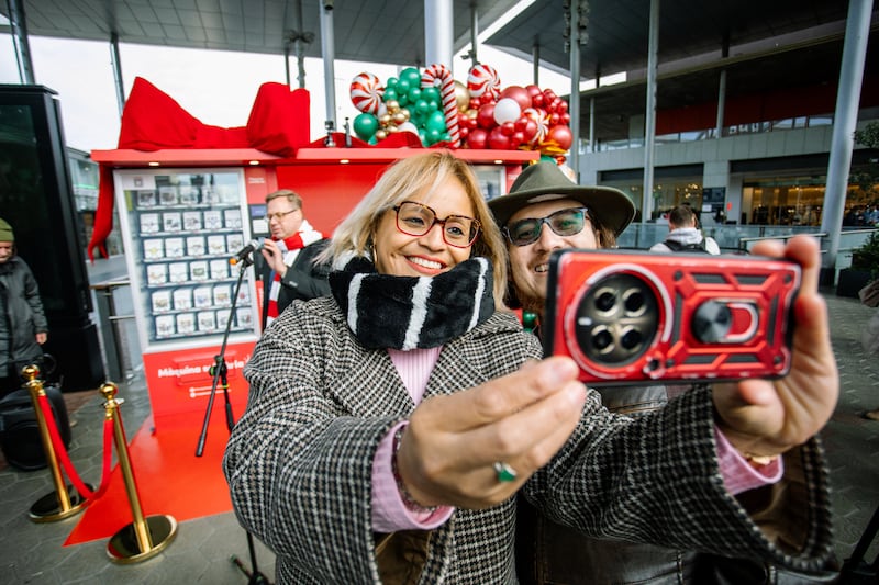 Two guests pose for a selfie in front of the new Giving Machines located in Barcelona, Spain, on Nov. 28, 2025.