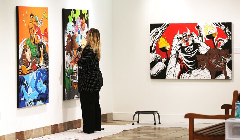 Lisa Jensen who is the art educator at the museum works on a piece that they hope to auction off as parents and kids enjoy coloring the different art pieces at the Woodbury Art Museum's "Heroes and Villains: How Mythology Made Comics" exhibition at Univer
