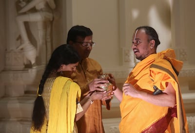 Priest Satish Kumar Nenmali, right, recites the names and lineage of devotees Vidya Anand, left, and Krishnan Anand before they perform abhishekam to Shiva Lingam during Maha Shivaratri at the Sri Ganesha Hindu Temple of Utah in South Jordan on Monday, Ma