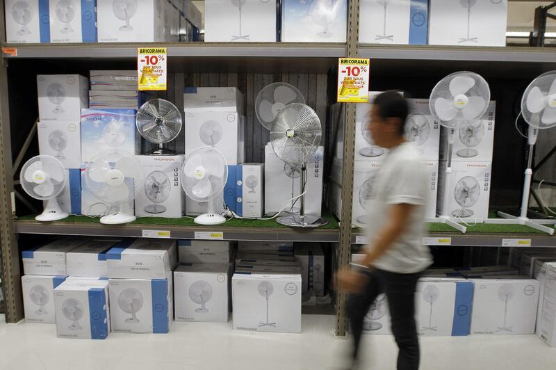 In this July 3, 2015 file photo, a person walks past a store shelf filled with fans in Marseille, southern where the temperature rose to 89.6 Fahrenheit. Federal officials said Earth in July broiled to the hottest month on record, smashing old marks.