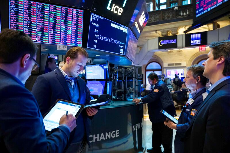 Traders gather at a post on the floor.