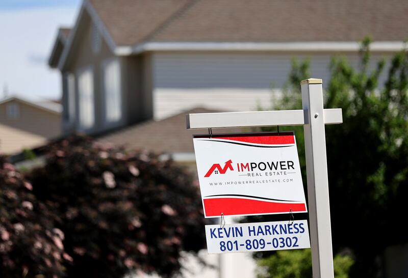 A “for sale” sign is posted in the yard of a house in Sandy on Tuesday, May 31, 2022.