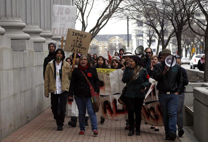 Protestors march in protest of HB497, Utah's immigration enforcement law, outside of the Frank E. Moss Courthouse in Salt Lake City on Friday, Feb. 17, 2012.