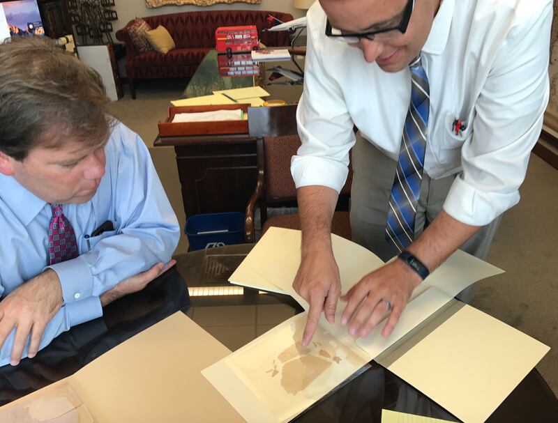 Reid Neilson and Robin Jensen look at fragments of original manuscript of the Book of Mormon.