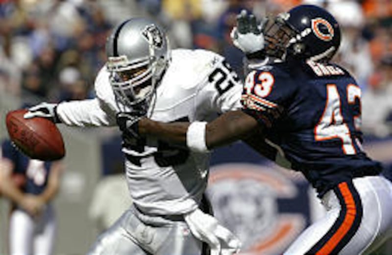 Oakland Raiders running back Charlie Garner, left, is taken down by Chicago Bears safety Mike Green.