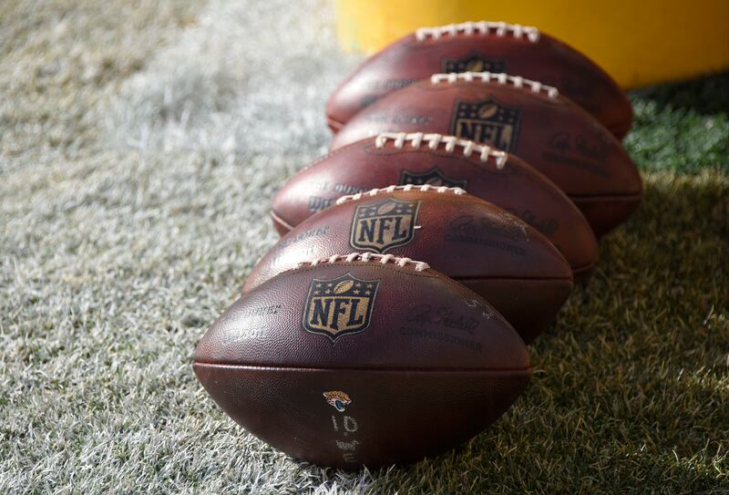 FILE - In this Jan. 14, 2018 file photo, NFL footballs sit on the field during warm ups before an NFL divisional football AFC playoff game between the Pittsburgh Steelers and the Jacksonville Jaguars in Pittsburgh. The NFL wants Congress to enact a framew