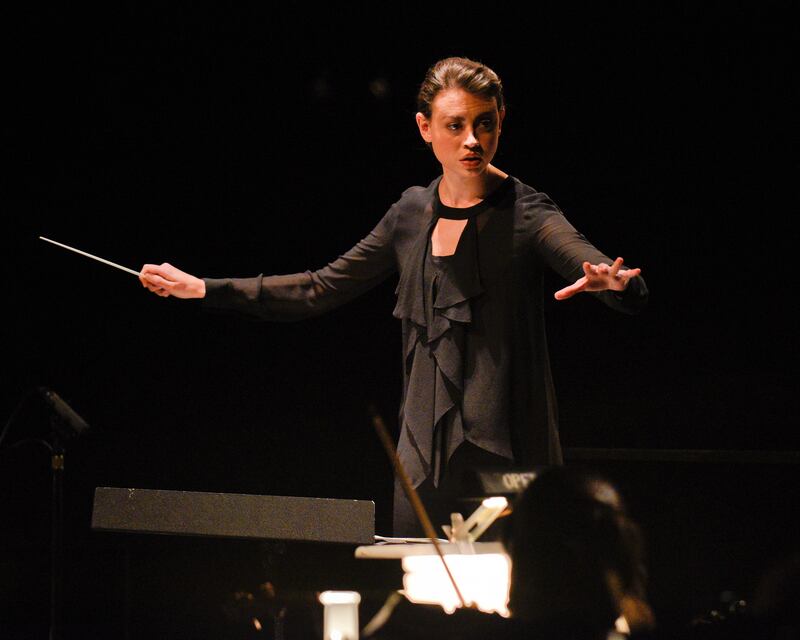 Stephanie Rhodes Russell conducting an orchestra. Russell is the founder of Women's Artistic Leadership Initiative.