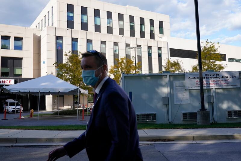A U.S. Secret Service agent walks outside Walter Reed National Military Medical Center, in Bethesda, Md., before President Donald Trump arrives Friday, Oct. 2, 2020, after he tested positive for COVID-19.