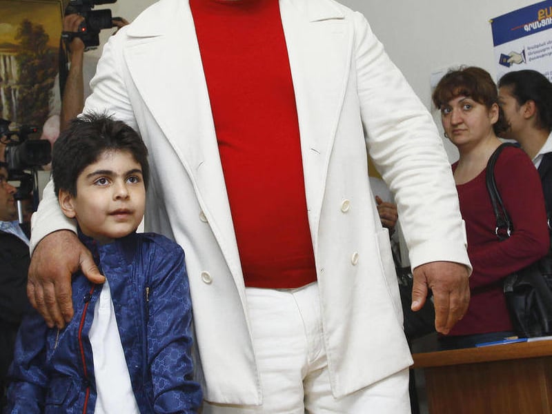 Armenia Party President Gagik Tsarukyan walks with his son Nver to cast his ballot, during parliamentary elections in Yerevan, Armenia on Sunday, May 6, 2012.
