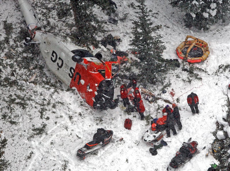 Rescue crews check out the scene of a helicopter crash near Soapstone Basin where one of two U.S. Coast Guard helicopters crashed into a mountain Wednesday above Kamas, Utah. There were five people on board the HH-60 Jayhawk, which was returning from secu