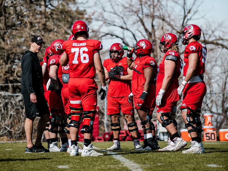 Utah offensive line coach Jim Harding gets in some work with his linemen during spring drills in Salt Lake City.