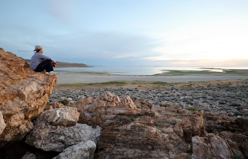 Aleks Kupe watches the sunset over the Great Salt Lake on Antelope Island on June 5, 2023.