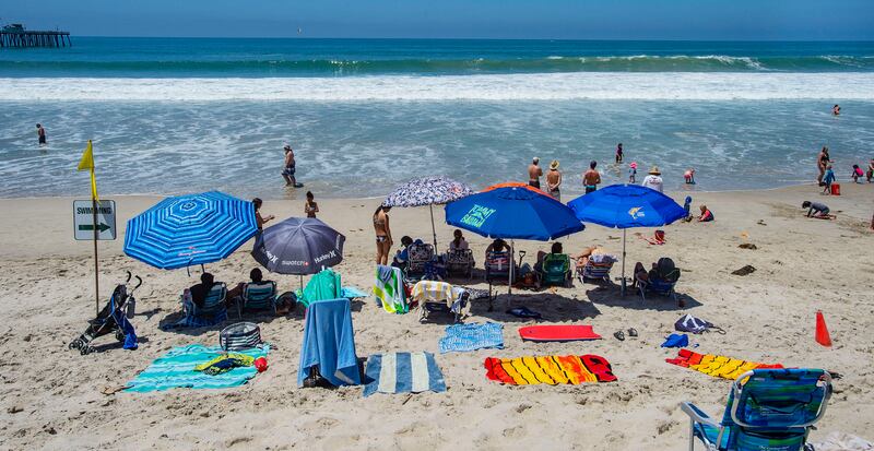 With most of Southern California’s coastline is shut down for the Fourth of July holiday due to a spike in coronavirus cases, the beach in San Clemente, Calif., remains open as crowds, socially distanced, fill the sand Saturday, July 4, 2020.