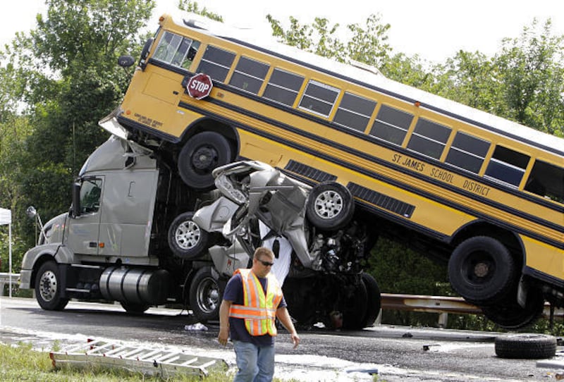 A rescue worker is seen at the scene of an accident involving two school buses, a tractor-trailer and another passenger vehicle on Thursday on an interstate near Gray Summit, Mo.