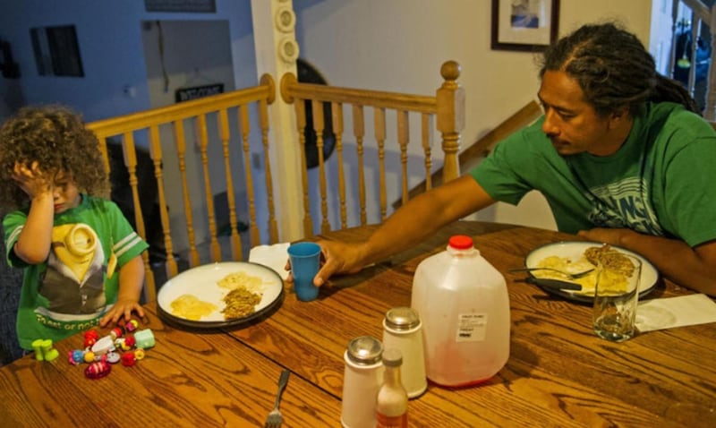 Ami Tuatonga passes a glass of juice to his son, Maake, during suppertime at their home in West Valley City on Thursday, Oct. 6, 2016.