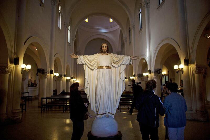 In this May 11, 2013 photo, a woman looks up at a statue of Jesus Christ in the San Jose del Talar parish, in Buenos Aires, Argentina. With an Argentine on the throne of St. Peter, the South American country's capital city has launched a series of guided