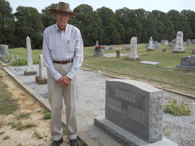 In this undated photo, 81-year-old Paul Muhle stands next to a gravestone at Wolf Valley Cemetery in Brown County, Texas. Muhle says he knows, or knows of “most everybody out here.”