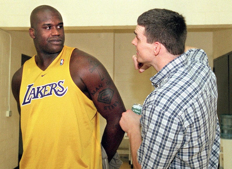 Mark Madsen jokes around with Shaquille O’Neal after a team basketball practice for the LA Lakers.