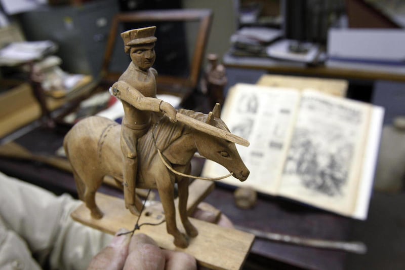 In this Thursday, Nov. 3, 2011, photo, Soldiers and Sailors Hall curator and historian, Michael Kraus shows a toy wooden horse from the U.S. Civil War era in a storage area at the Soldiers & Sailors Memorial museum in Pittsburgh. This and other letters a