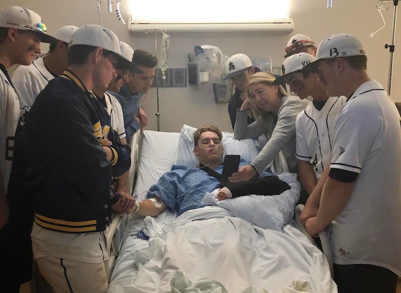 Summit Academy baseball players gather around Kolby Hamblin after his emergency surgery at the IMC hospital in Murray.