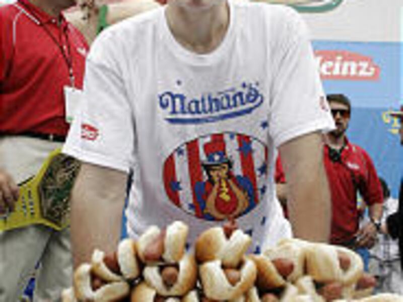 Joey Chestnut poses with a plate of 66 hot dogs after winning Nathan's Famous Hot Dog Eating Competition in New York, Wednesday. The Californian knocked off six-time titlist Takeru Kobayashi in a rousing yet repulsive triumph in Coney Island.