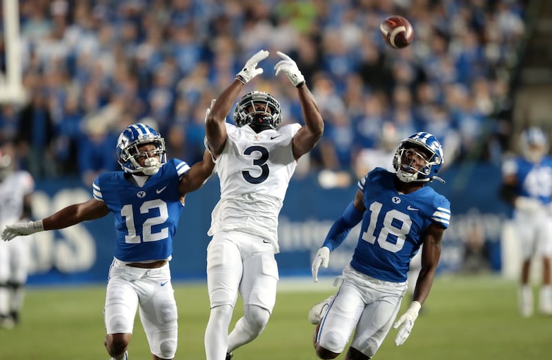 BYU defensive backs Malik Moore (12) and Kaleb Hayes defend Virginia’s Dontayvion Wicks at LaVell Edwards Stadium in Provo.