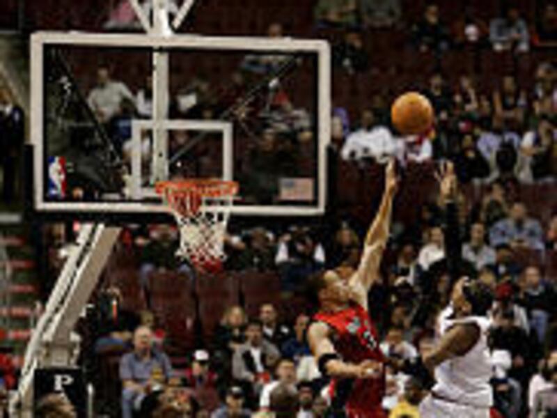 As the shot clock winds down, 76ers' Allen Iverson, right, takes a shot against the Toronto Raptors.