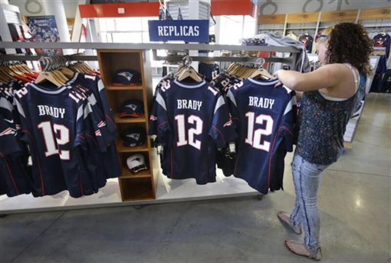 Miguelina Huertas, of Worcester, Mass., right, examines jerseys featuring the name and number of New England Patriots football quarterback Tom Brady in the ProShop at Gillette Stadium, Wednesday, May 13, 2015, in Foxborough, Mass. Brady was suspended by t