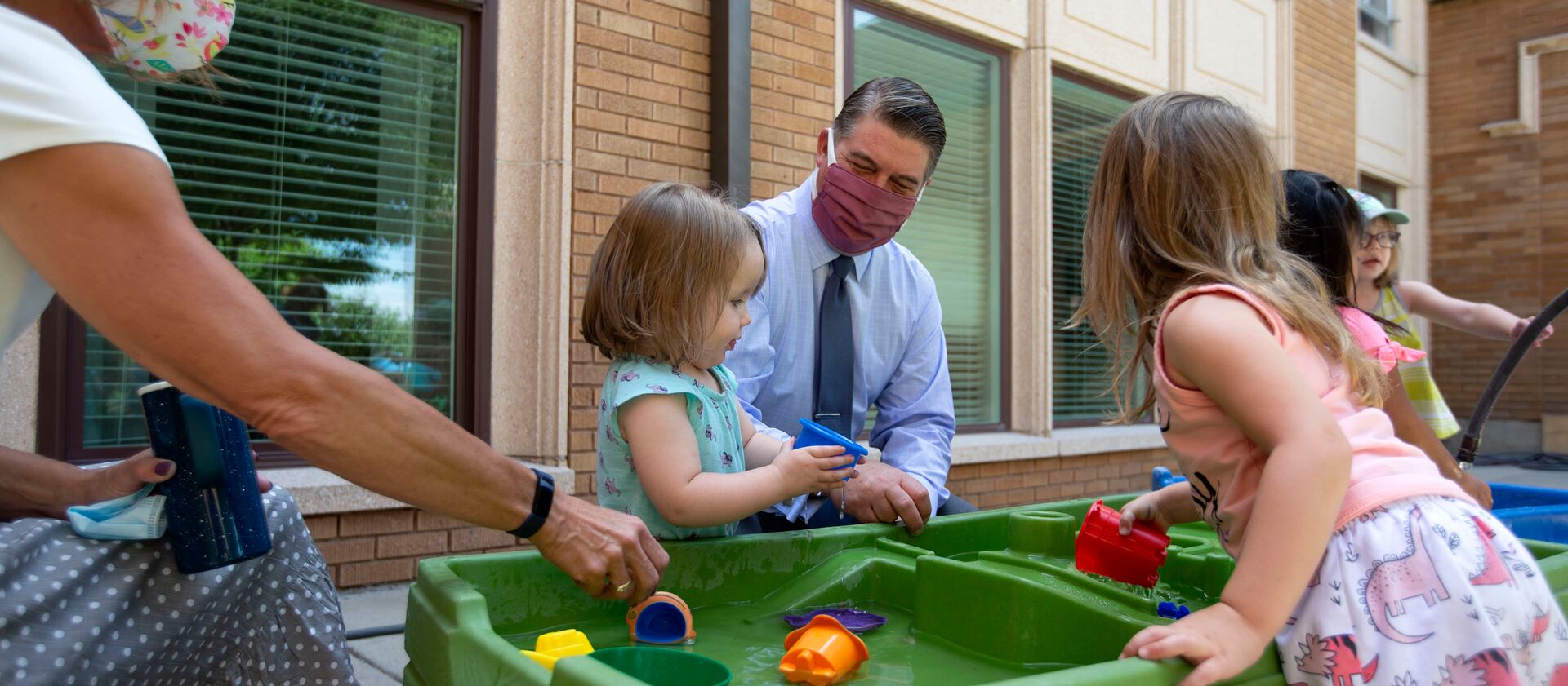 Leaders of First Baptist Child Development Center in Salt Lake City play outside with children in June 2020.