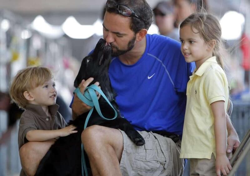 Marc Wyerstall and his children, Alex and Amelia, try to decide on adopting a young dog in Salt Lake City this past July.