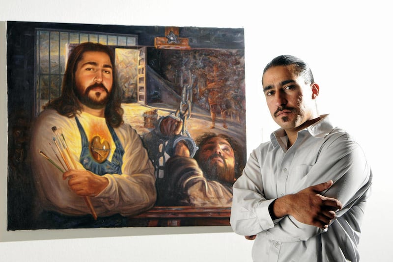 In this Tuesday, July 26, 2011 photo, painter Eric Christo Martinez, poses with one of his paintings that now hangs at the Albuquerque Museum, in Albuquerque, N.M..