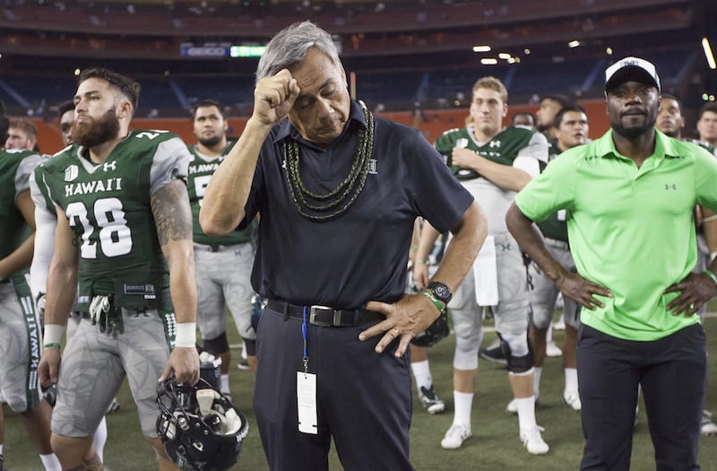 Hawaii coach Norm Chow wipes his brow after the team's 58-7 loss to Air Force in an NCAA college football game, Saturday, Oct. 31, 2015, in Honolulu. (AP Photo/Eugene Tanner)