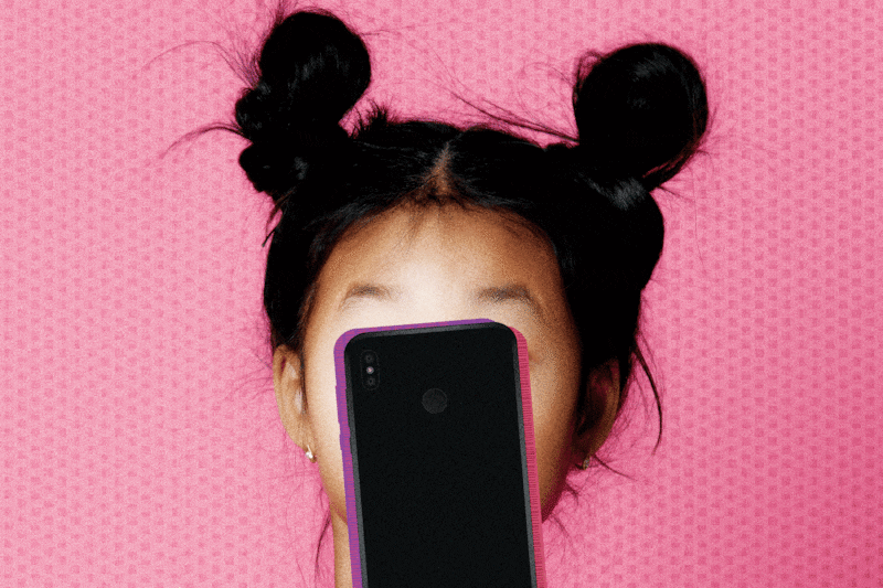 A young “zoomer” of the Gen Z generation is completely absorbed with their smartphone.