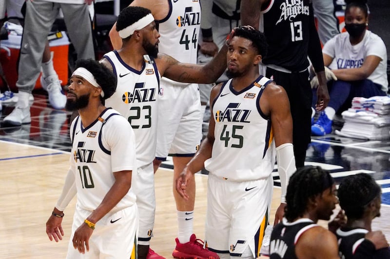 Utah Jazz forward Royce O’Neale, center, pats guard Donovan Mitchell, right, on the head as guard Mike Conley walks away