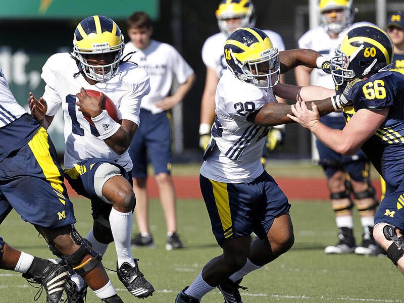 Michigan quarterback Denard Robinson (16) runs through a hole as running back Fitzgerald Toussaint (28) blocks defensive tackle Alex Schwab (60) during NCAA college football practice in New Orleans, Friday, Dec. 30, 2011, for the upcoming BCS Sugar Bowl