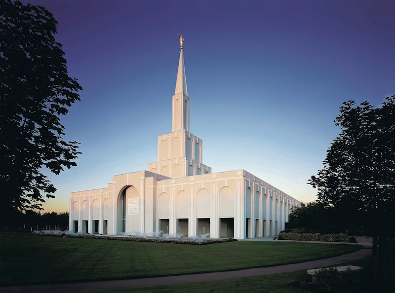 The Toronto Ontario Canada Temple is shown against a plain blue sky.