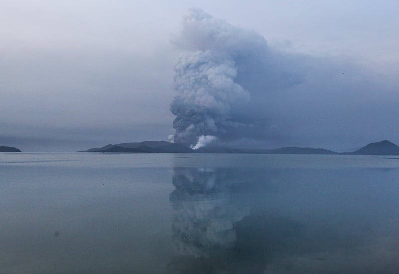 Taal volcano spews ash in view from Batangas, southern Philippines on Monday, Jan. 13, 2020. Red-hot lava gushed out hereof a volcano near the Philippine capital on Monday, as thousands of people fled the area through heavy ash. Experts warned that the eruption could get worse and plans were being made to evacuate hundreds of thousands. (AP Photo/Gerrard Carreon)