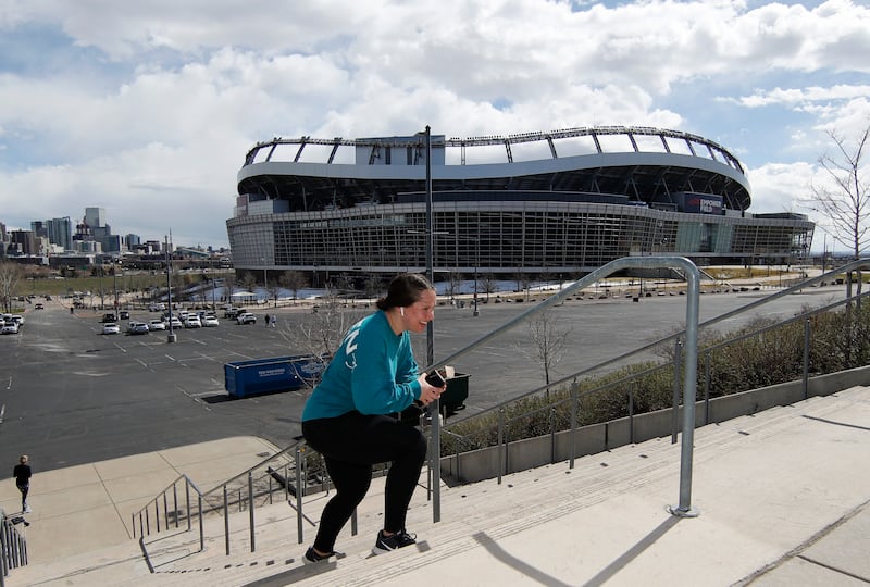 Andrea Lenneman of Denver runs a flight of stairs outside Mile High Stadium in Denver.