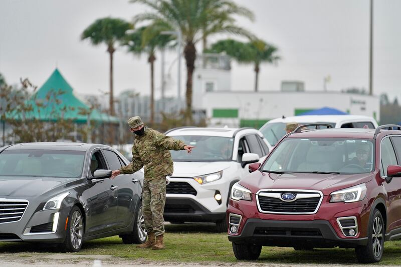 A member of the Florida National Guard directs people waiting in line for the coronavirus vaccine at an outdoor vaccination site at Lakewood Ranch Wednesday, Feb. 17, 2021, in Bradenton, Fla.